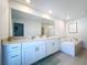 Bright bathroom featuring double vanity, soaking tub and tile floor at 32046 Powderpuff Mimosa Dr, San Antonio, FL 33576