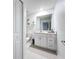 Bright bathroom with modern vanity, mirror, decorative shelves, and tiled floor at 32046 Powderpuff Mimosa Dr, San Antonio, FL 33576
