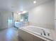 Bright bathroom with white cabinets, soaking tub and modern fixtures at 32046 Powderpuff Mimosa Dr, San Antonio, FL 33576