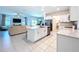 Open-concept kitchen flows into the living area, featuring white cabinets, stainless steel appliances, and an island at 32046 Powderpuff Mimosa Dr, San Antonio, FL 33576