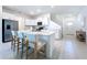 Bright kitchen features white cabinets, stainless steel appliances, and a large island with bar stool seating at 32046 Powderpuff Mimosa Dr, San Antonio, FL 33576