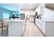 Open concept kitchen with white cabinetry, stainless steel appliances, central island with seating overlooking the living area at 32046 Powderpuff Mimosa Dr, San Antonio, FL 33576