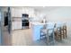 Modern kitchen boasts an island with seating, stainless steel appliances, sleek white cabinets, and stylish tile flooring at 32046 Powderpuff Mimosa Dr, San Antonio, FL 33576