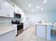 Bright, modern kitchen featuring stainless steel appliances, white cabinets, quartz countertops, and an island with bar seating at 32046 Powderpuff Mimosa Dr, San Antonio, FL 33576
