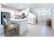 Modern kitchen features an island with seating, stainless steel appliances, white cabinets, and tile flooring at 32046 Powderpuff Mimosa Dr, San Antonio, FL 33576