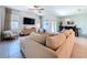 Living room features neutral decor, comfortable sofa, and sliding door access to outdoor space at 32046 Powderpuff Mimosa Dr, San Antonio, FL 33576