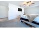 Bright main bedroom with TV, ceiling fan and grey carpet at 32046 Powderpuff Mimosa Dr, San Antonio, FL 33576