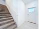 View of carpeted stairs with white railings, and a door with window insert for bright, natural lighting at 32046 Powderpuff Mimosa Dr, San Antonio, FL 33576