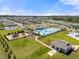 Aerial view of the community highlighting the pool, playground, clubhouse, and surrounding neighborhood at 36519 Garden Wall Way, Zephyrhills, FL 33541