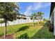 Well-manicured backyard with lush green lawn, a white fence, and mature trees enhancing the outdoor space at 36519 Garden Wall Way, Zephyrhills, FL 33541