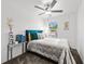 Comfortable bedroom with silver comforter and decorative pillows, bathed in natural light from the window at 36519 Garden Wall Way, Zephyrhills, FL 33541