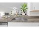 Close-up of a granite kitchen countertop with a stainless steel sink and a view of the living area at 36519 Garden Wall Way, Zephyrhills, FL 33541