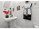 Cozy powder room featuring a pedestal sink, round mirror, and stylish black and white hand towels at 36519 Garden Wall Way, Zephyrhills, FL 33541