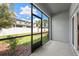 Relaxing screened porch overlooking a well-maintained yard with palm trees and a white fence at 36519 Garden Wall Way, Zephyrhills, FL 33541