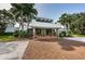 The clubhouse features a brick-paved driveway leading to a modern building with stone accents and tall palm trees at 36750 Us 19 N # 3-124, Palm Harbor, FL 34684