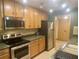 Efficient kitchen with stainless steel appliances, warm wood cabinets, and neutral countertops at 36750 Us 19 N # 3-124, Palm Harbor, FL 34684