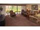 Inviting living room with comfortable seating, neutral carpet, and sliding glass door to outdoor patio at 36750 Us 19 N # 3-124, Palm Harbor, FL 34684