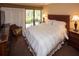 Relaxing bedroom with a queen-size bed, outdoor patio, and view of the landscaping at 36750 Us 19 N # 3-124, Palm Harbor, FL 34684