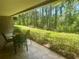 Relaxing covered patio view with table and chairs overlooking the beautiful trees and landscaping at 36750 Us 19 N # 3-124, Palm Harbor, FL 34684