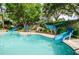 Outdoor pool with waterslides and lush greenery on a sunny day at a resort at 36750 Us 19 N # 3-124, Palm Harbor, FL 34684