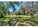 Spacious backyard featuring a shed and mature trees, perfect for outdoor activities and relaxation in a private setting at 4041 Lane Rd, Zephyrhills, FL 33541
