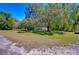 View of home across a large, green front lawn, accented by mature trees providing ample shade at 4041 Lane Rd, Zephyrhills, FL 33541