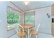 Charming kitchen featuring a round wooden table, white chairs, and bright natural light at 4041 Lane Rd, Zephyrhills, FL 33541