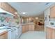 Cozy kitchen featuring white appliances and ample cabinet space, open to the dining area at 4041 Lane Rd, Zephyrhills, FL 33541