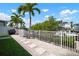 Charming backyard featuring palms, a white fence, stepping stones, and view of a canal with docked boats at 424 Bahama Grande Blvd, Apollo Beach, FL 33572