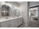 Bright bathroom with double sinks and mirrors, next to bedroom with TV and ceiling fan at 424 Bahama Grande Blvd, Apollo Beach, FL 33572