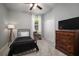 Cozy bedroom featuring a metal bed frame, dresser with a TV, and natural lighting at 424 Bahama Grande Blvd, Apollo Beach, FL 33572