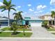 Charming home features lush landscaping, two-car garage, and a welcoming, light blue exterior and paver driveway at 424 Bahama Grande Blvd, Apollo Beach, FL 33572
