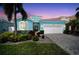 Beautifully landscaped home with a turquoise exterior, paved driveway, and lush tropical foliage at sunset at 424 Bahama Grande Blvd, Apollo Beach, FL 33572