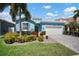Charming, single-story home features lush landscaping, two-car garage, and a welcoming, light blue exterior at 424 Bahama Grande Blvd, Apollo Beach, FL 33572