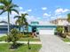 Charming home features lush landscaping, two-car garage, and a welcoming, light blue exterior and paver driveway at 424 Bahama Grande Blvd, Apollo Beach, FL 33572