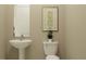 Elegant half bathroom featuring a modern pedestal sink, toilet, and stylish decor at 4807 Southern Valley Loop, Brooksville, FL 34601