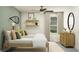 Well-lit, relaxing bedroom with two twin beds, soft textures, decorative shelving and a ceiling fan at 4807 Southern Valley Loop, Brooksville, FL 34601