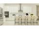 Modern kitchen with stainless steel appliances, white cabinets, large island and counter seating at 4807 Southern Valley Loop, Brooksville, FL 34601