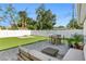 Spacious backyard featuring a patio with outdoor seating, artificial grass, and white fencing at 5298 Oxford N Ave, St Petersburg, FL 33710