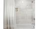 Clean bathroom showcasing a white bathtub, marble-tiled walls, and a sleek chrome showerhead at 5298 Oxford N Ave, St Petersburg, FL 33710