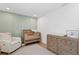 Charming Bedroom with a modern crib, dresser, an accent chair, and hardwood floors at 5298 Oxford N Ave, St Petersburg, FL 33710