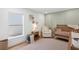 Cozy Bedroom with soft green walls, a wooden crib, an accent chair, and a serene window view at 5298 Oxford N Ave, St Petersburg, FL 33710