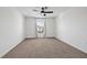 An empty bedroom with carpet, a ceiling fan, and a large window overlooking the outdoors at 5429 Companion Ln, Tampa, FL 33619