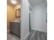 Hallway view of the updated bathroom featuring a vanity with a grey cabinet at 6765 Ralston Beach Cir, Tampa, FL 33614