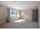 Sunlit bedroom with neutral walls, carpet, and a view through a large window at 6765 Ralston Beach Cir, Tampa, FL 33614