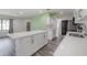 Modern kitchen featuring white cabinets, stone countertops and gray wood flooring at 6765 Ralston Beach Cir, Tampa, FL 33614