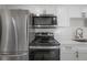 Well appointed kitchen features a full compliment of stainless appliances and white cabinetry at 6765 Ralston Beach Cir, Tampa, FL 33614
