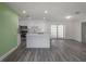Open concept living room and kitchen featuring stainless steel appliances and ample natural light at 6765 Ralston Beach Cir, Tampa, FL 33614