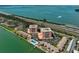 An aerial view showcases the condos, a pool, tennis court, and nearby coastal highway at 7430 Sunshine Skyway S Ln # 403, St Petersburg, FL 33711
