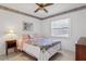 Cozy bedroom featuring a colorful bedspread, ceiling fan, and natural light from the window at 747 Stillview Cir, Brandon, FL 33510